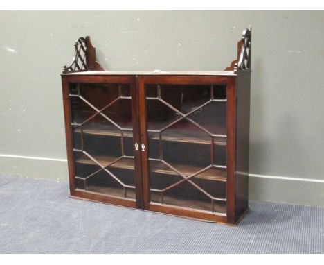 A George III mahognay wall hanging cupoard with fretcut supports, the astragal glazed doors enclosing a shelf, 93 x102 x 25cm