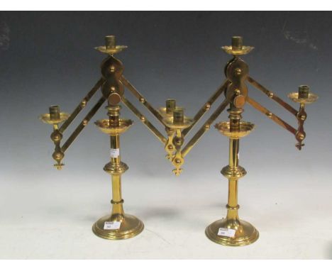 A pair of adjustable three light brass candelabra