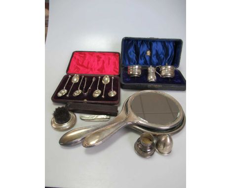 A collection of silverware including flatware, a cased three-piece condiment set, silver backed brushes, mirrors and comb, si