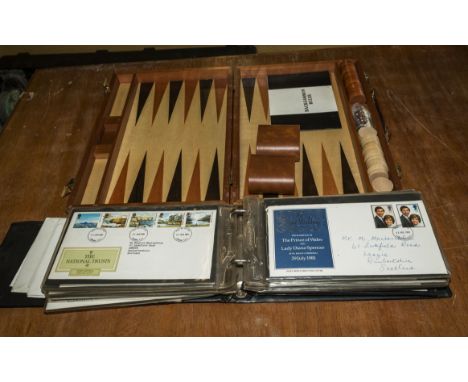 A backgammon set and a folder of first covers