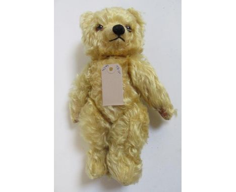 A Chad Valley musical teddy bear, in pale gold plush, amber and black glass eyes, cloth pads, with wind-up movement playing "