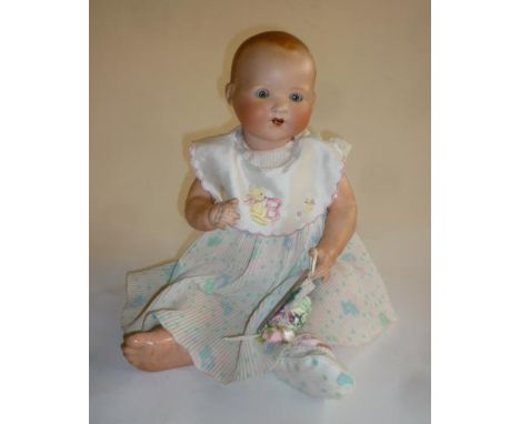 An Armand Marseille bisque head baby doll with fixed blue glass eyes, open mouth and teeth, moulded hair, composition bent li