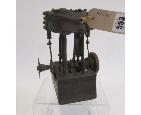 A twin cylinder steam compound engine, non-reversing, high and low pressure cylinders, on wooden base, some parts rusting, re