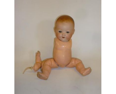 An Armand Marseille bisque head boy doll with blue glass sleeping eyes, open mouth and teeth, moulded hair, composition bent 