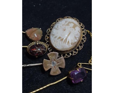 A selection of yellow metal stick pins and a cameo brooch 