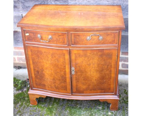 A walnut and banded bowfront side cupboard, fitted two drawers, on bracket feet, 29" wide
