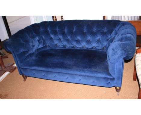 A 19th century Chesterfield two-seat settee, upholstered an a blue velour, on turned supports, 67" wide