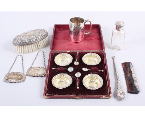 A boxed set of four silver salts and spoons, a comb, a button hook, a christening mug, a brush, a dressing table bottle and s