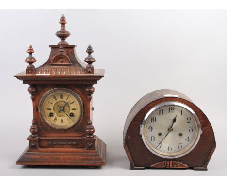 An oak cased mantel clock with finials and carved decoration, Roman numerals and an enamel dial, 17" high, and an Enfield oak