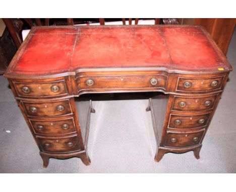 A mahogany shape front double pedestal desk with tooled red leather top, fitted nine drawers, on bracket feet, 41" high