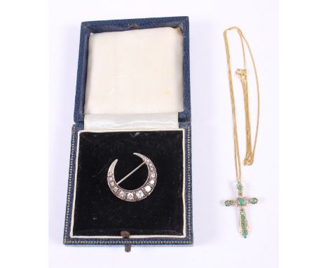 A 9ct gold, emerald and diamond set pendant, in the form of a cross, on a 9ct gold chain, 2.5g, and a white metal crescent-sh
