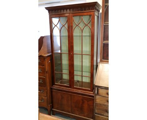 A mahogany display cabinet enclosed Gothic lattice doors over cupboards, on bracket feet, 32" wide x 74 1/2" high