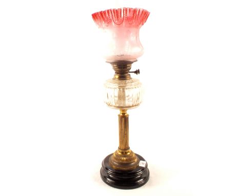 A brass column oil lamp with pink etched glass shade
