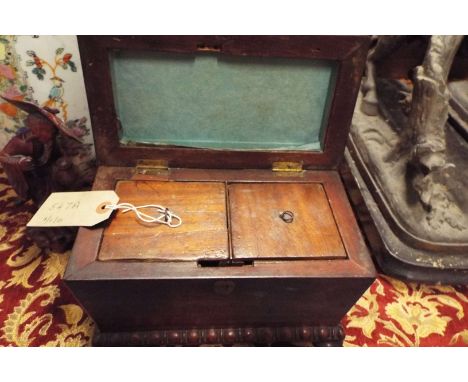A mahogany sarcophagus shaped tea caddy with beaded decoration resting on bun feet