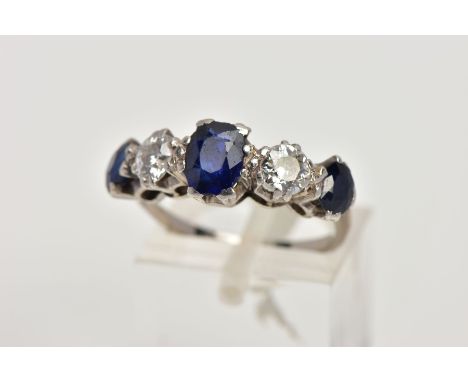 A WHITE METAL DIAMOND AND SAPPHIRE FIVE STONE RING, designed with three four claw set, oval cut blue sapphires, interspaced w