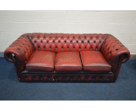 AN OXBLOOD LEATHER THREE SEATTER CHESTERFIELD SOFA, outer width 190cm (condition - cracks and tears to arms, seat base worn t