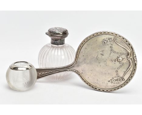 A SILVER VANITY MIRROR, SILVER LIDDED GLASS JAR AND A SILVER MOUNTED GLASS MATCHSTICK TIDY, the mirror decorated with an embo