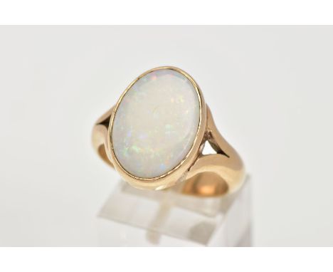 A HEAVY 9CT GOLD OPAL RING, designed with an oval cut opal cabochon, measuring approximately 12.0mm x 7.3mm, collet mount, bi