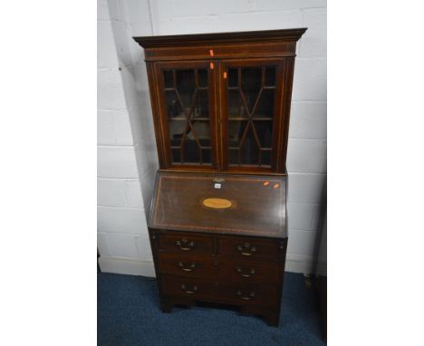 AN EDWARDIAN MAHOGANY AND INLAID BUREAU BOOKCASE, the fall front enclosing a fitted interior, above two short drawers over tw