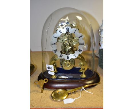 A LATE VICTORIAN BRASS SKELETON CLOCK UNDER A GLASS DOME, the clock with silvered dial with Roman numerals, single fusee move