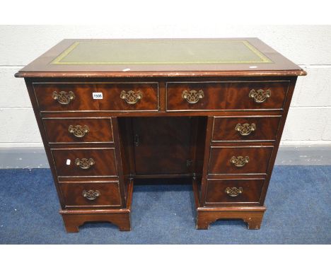 A MAHOGANY KNEE HOLE DESK, the top with a green tooled leather inlay, eight various drawers, single cupboard doors, on bracke