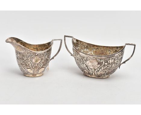 A SILVER CREAMER AND MATCHING SUGAR BOWL, the creamer embossed with a foliate and scroll design with a vacant cartouche, hall