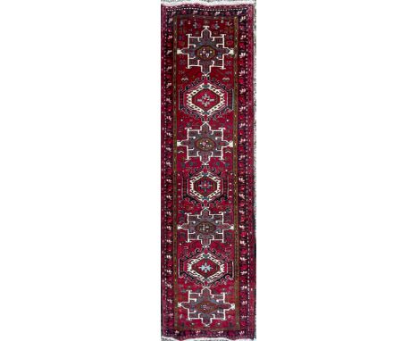 An early 20th century North West Persian Islamic Heriz hand woven floor carpet runner rug having a central panel with alterna