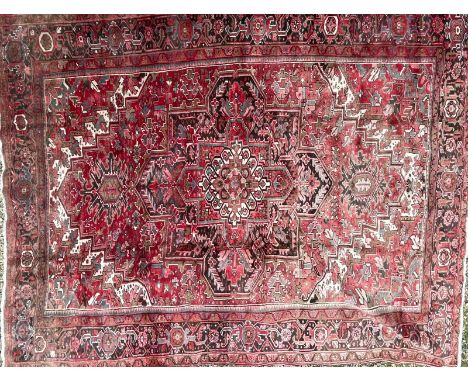 A 19th century Central Persian Islamic Heriz hand woven floor carpet rug having a central panel with graduating central medal