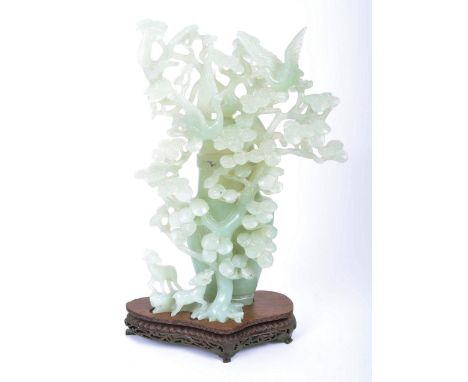 A 19th century intricate jade sculpted lidded vase presented upon mahogany carved stand. Lid topped with three flapping and c