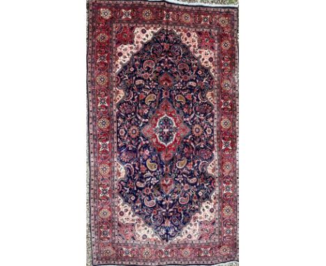 A 19th century North West Persian Islamic Sarouk hand woven floor carpet rug having a central cobalt medallion within in cent