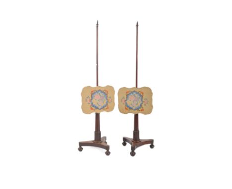 A pair of early 19th century Regency mahogany pole fire screens. The screens each having spindles to top over conical columns