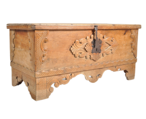 An 18th century Continental pine carved embellished coffer trunk chest. The coffer having a split wire hinged top over carved