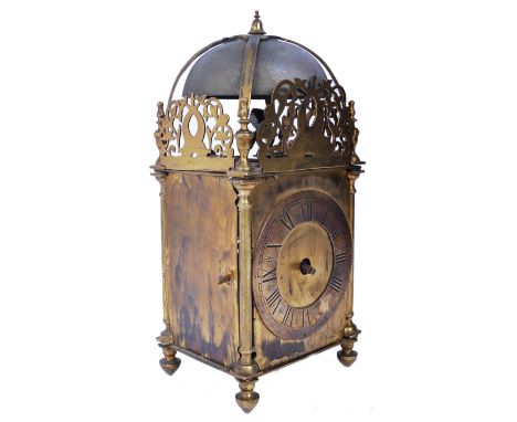 A late seventeenth century Charles II brass lantern clock, with bell raised atop vase haped finials surrounded by foliate rep