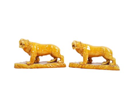 A pair of 19th century Victorian glazed ceramic tigers with each in a&nbsp;prowling position with mouths open and teeth showi