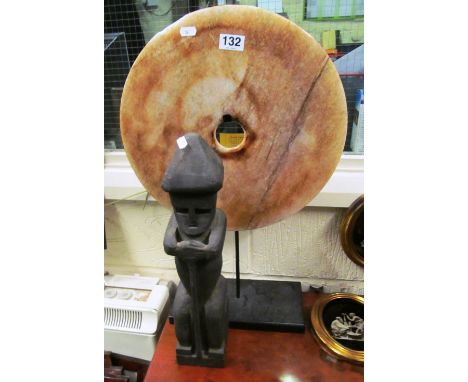 A stoneware disc on hanger and African stick man