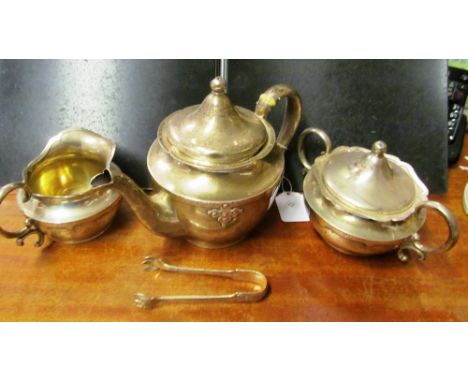 A Shreve &amp; Co. Sterling silver Arts &amp; Crafts style three piece teaset and matching sugar tongs (teapot slightly a/f)