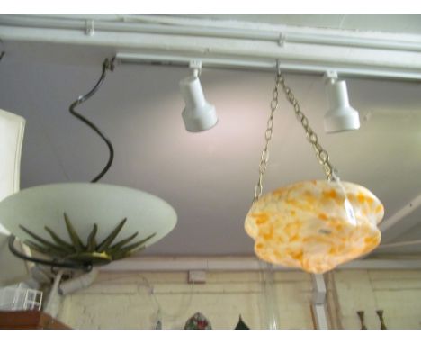 A hanging metal and glass ceiling light and a white and orange mottled ceiling light