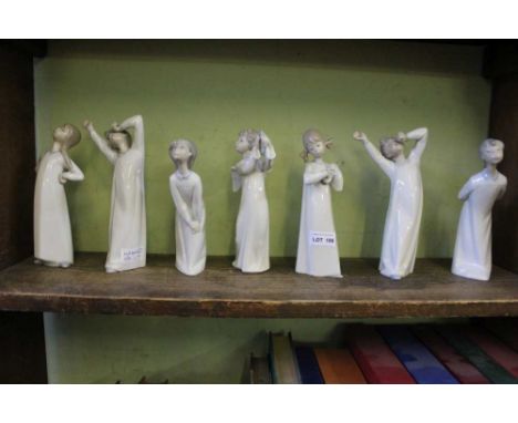 A SHELF FULL OF SPANISH PORCELAIN CHILDREN dressed in night gowns 