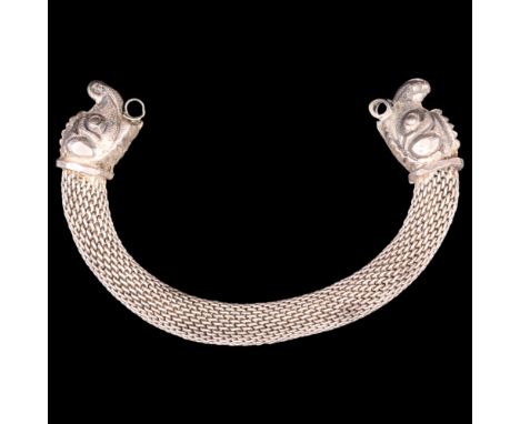 A Celtic-influenced white metal torque bangle, having terminals in the form of stylised beasts' heads, 70 g