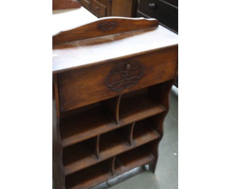 An early 20th century oak book shelf with carved top rail over drop flap over an arrangement of seven shelves, 64cmW x 101cmH