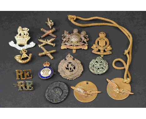 A Collection Of Mainly British Military Badges To Include The Manchester Regiment Cap Badge, Royal Army Ordnance Corps Cap Ba
