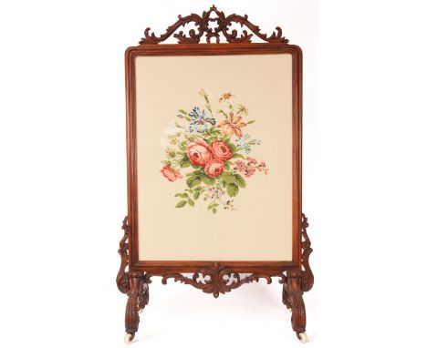 A MID 19th CENTURY CARVED ROSEWOOD FIRE SCREEN IN THE MANNER OF GILLOWS the leaf work carved cresting above a rectangular mou