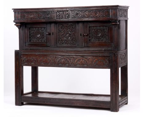 A CHARLES II SMALL OAK BUFFET OF GOOD COLOUR AND PATINA with boarded top above a carved frieze rail initialled R M. B M dated