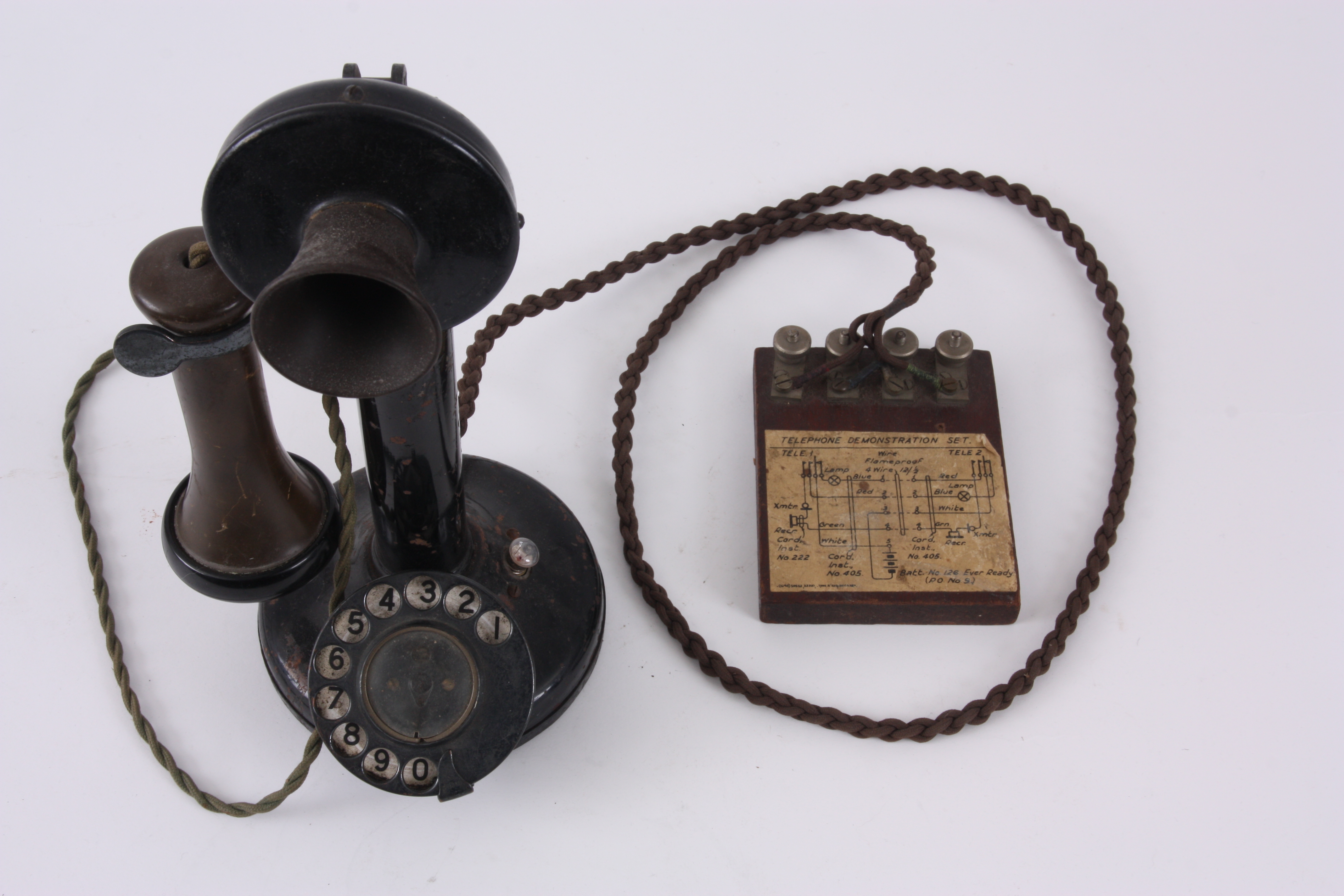 AN EARLY CANDLESTICK TELEPHONE with enamelled number dial and bakelite earpiece, the base with bu