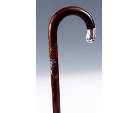 A LATE 19TH CENTURY SILVER INLAID ROSEWOOD WALKING STICK with crook handle, flower head decoration, and silver pommel 85cm ov