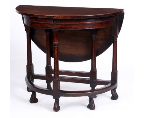 AN UNUSUAL EARLY 18TH CENTURY SEMI-CIRCULAR  JOINED OAK GAMES TABLE with hinged box top and fall leaf rear supported by a sid