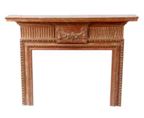 A GEORGE III STRIPPED PINE FIRE SURROUND with deep leaf moulded mantle above a breakfront centre panel carved with a fruiting