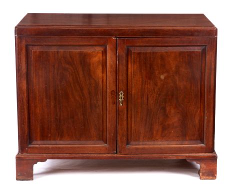 A GEORGE II CUBAN MAHOGANY LINEN PRESS with caddy edged top above a pair of panelled opening doors fitted with a later slide 