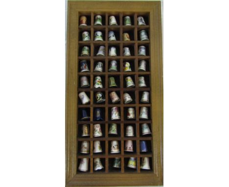 Wooden wall display containing 50 ceramic thimbles inc Royal Worcester, Spode and Masons