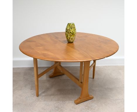 A Mid-Century Ercol Blonde elm and beech Model 610 drop leaf Sutherland oval dining table. Part of the Windsor range original